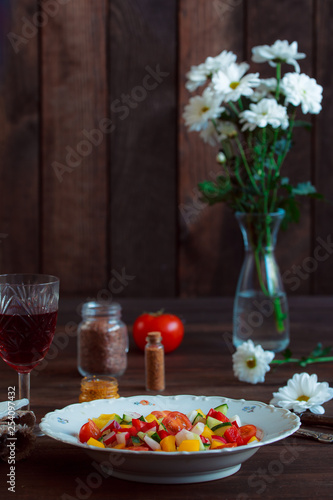 Spring vegetable salad. Healthy diet. First person view. Proper nutrition. Still life of daisies, a glass of wine fresh pepper, herbs and cutlery. Free space for lettering.