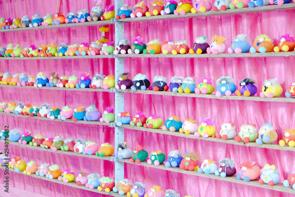 Perspective view of many dolls in multiple rows on the shelf