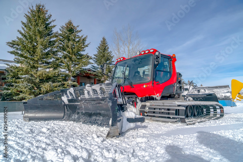 Snow groomer against snow trees and sky in Utah