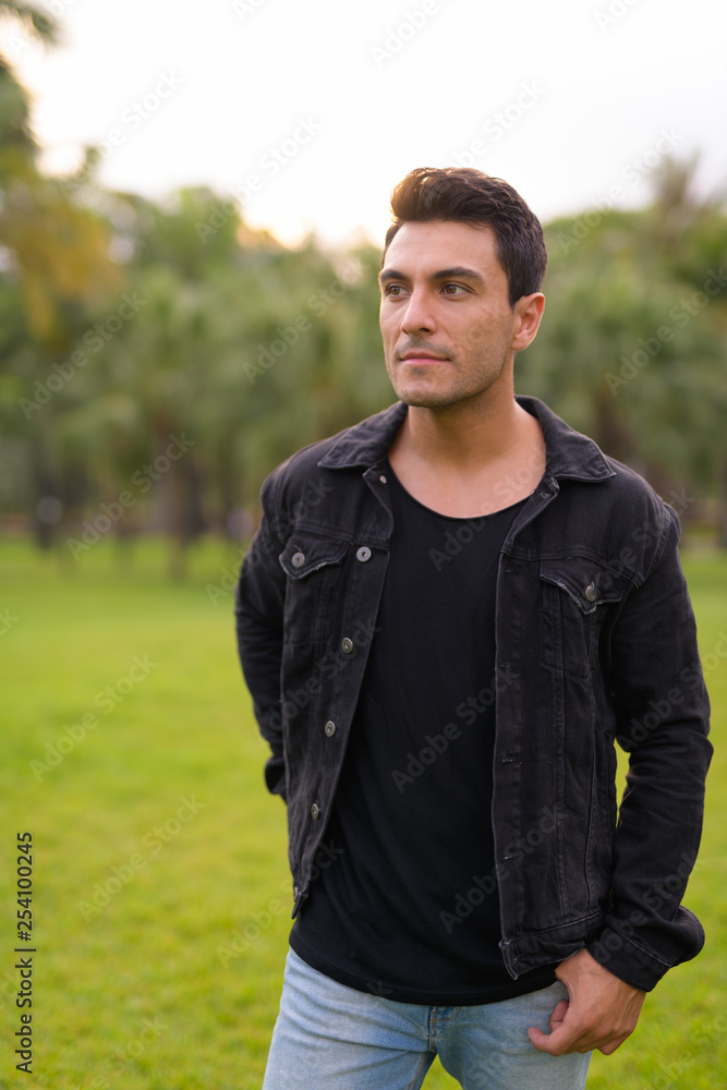 Young handsome Hispanic man thinking at the park outdoors Young handsome Hispanic man thinking at the park outdoors