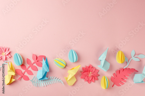 Easter holiday creative background with papercraft eggs, origami bunny on coral pink background, trendy paper craft holiday background