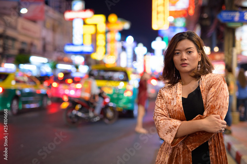 Young beautiful Asian tourist woman with arms crossed at Chinatown in Bangkok