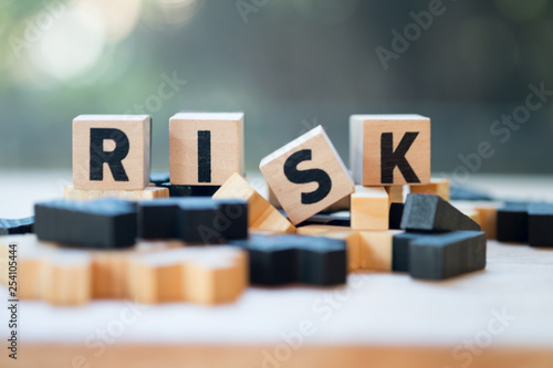 Cube wooden block with alphabet building the word RISK. Risk assessment photo