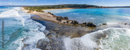 Aerial panoramic view of the Point Roadknight limestone rock outcrop with the beach, coastline and houses in Anglesea Victoria, Australia photo