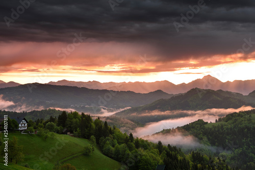 Sunrise in the mountains of Kamnik Savinja Alps with Storzic peak on right in pink fog over Skofjelosko Hills near Ljubljana Slovenia photo