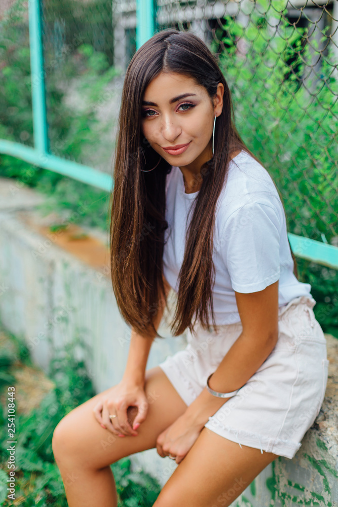 Portrait of a swag girl sitting next to rabitz fence Portrait of a swag girl sitting next to rabitz fence