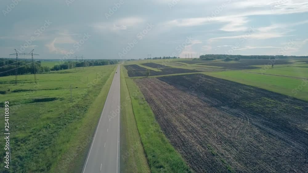 bird eye flight car drives along picturesque gray road under boundless blue summer sky with white clouds bird eye flight car drives along picturesque gray road under boundless blue summer sky with white clouds