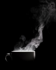 Steaming coffee in cup isolated on black background with copy space.
