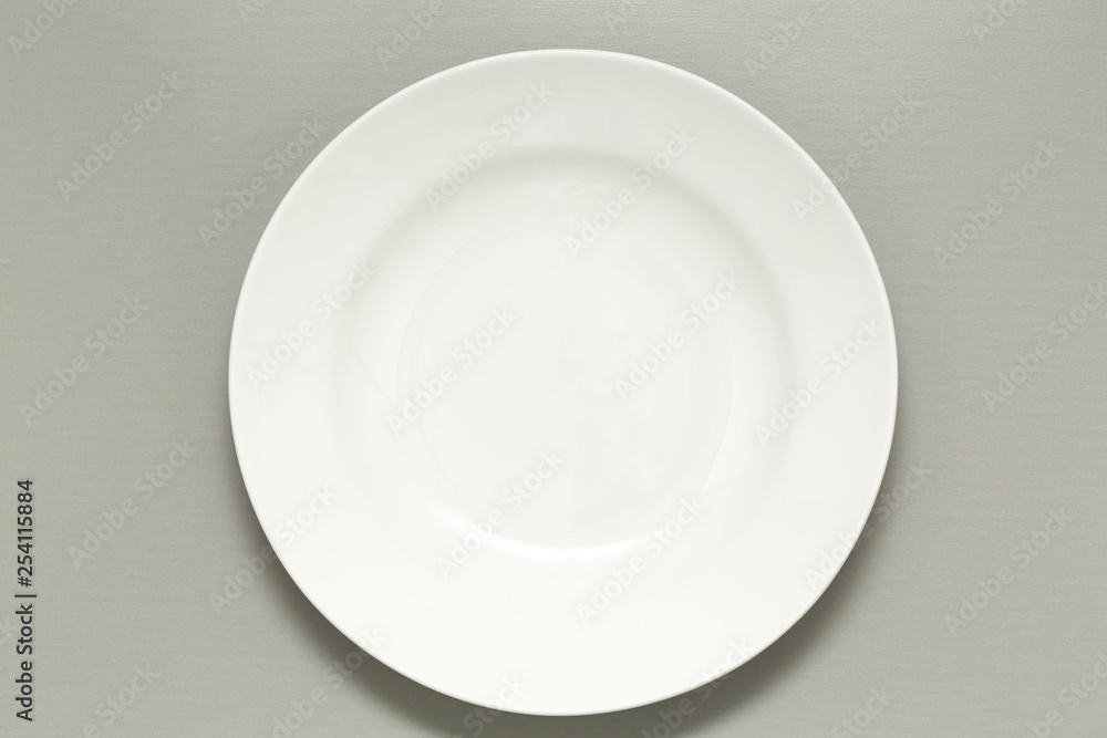Empty white ceramic Plate on gray background. Top view. Empty white ceramic Plate on gray background. Top view.