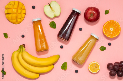 Colorful smoothies in bottles with fresh fruits on pink background. Flat lay. top view. Natural Organic Food Style. 