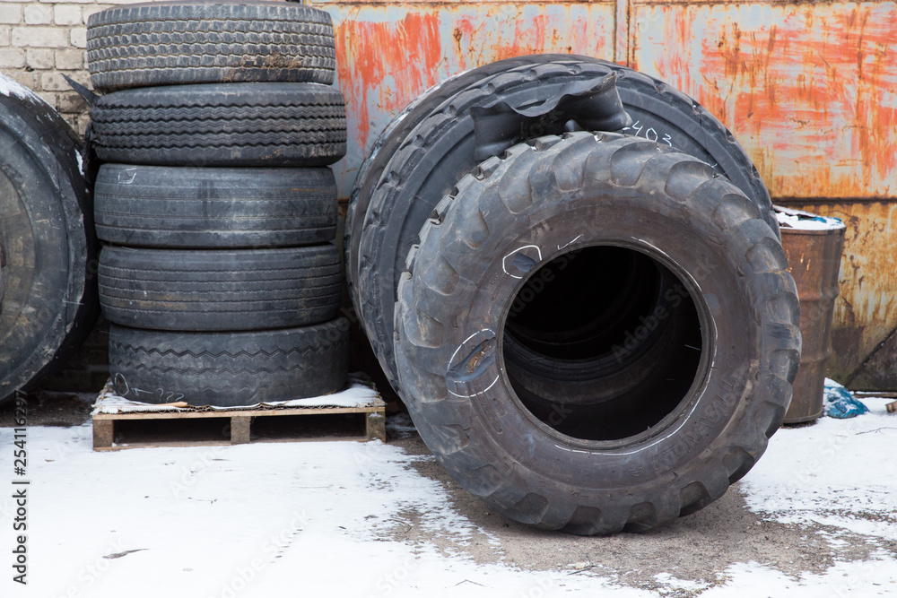 Big black tires in industrial park. Black rubber. Travel urban photo 2019. Big black tires in industrial park. Black rubber. Travel urban photo 2019.