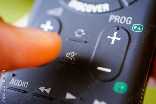 Wallpaper Mural Man holding tv remote commander and press mute button Torontodigital.ca