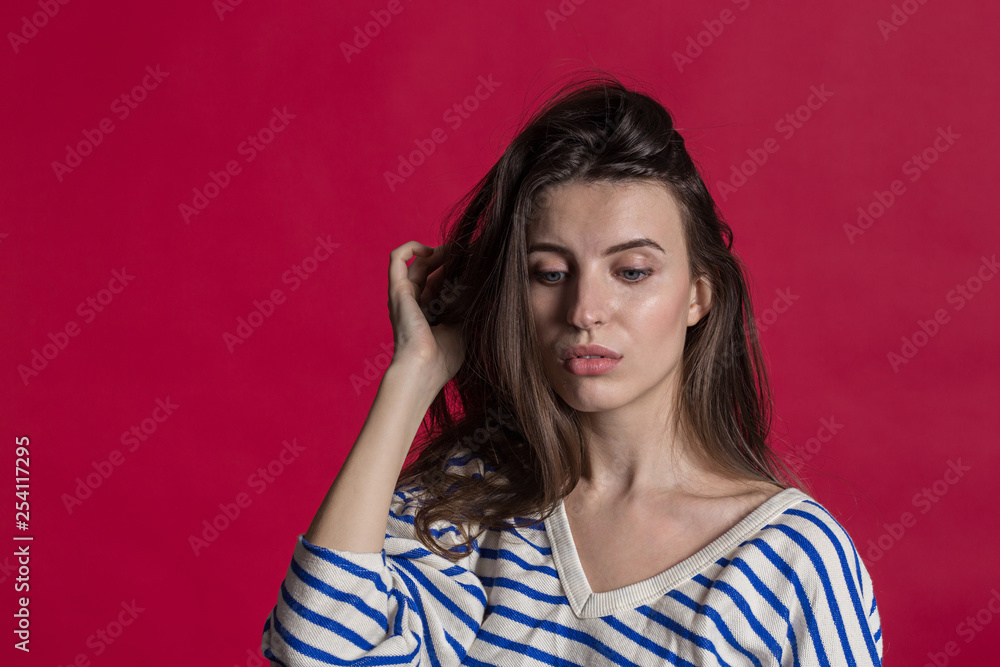 Studio shot of a lovely beautiful woman isolated against an empty red studio wall. Studio shot of a lovely beautiful woman isolated against an empty red studio wall.