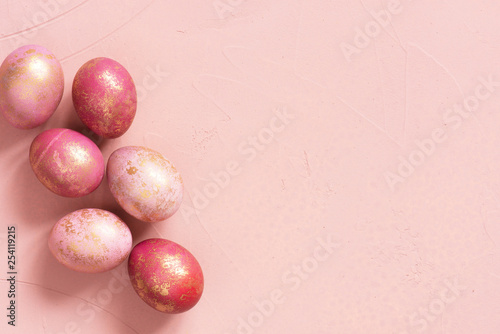 Background with pink Easter eggs with golden spots