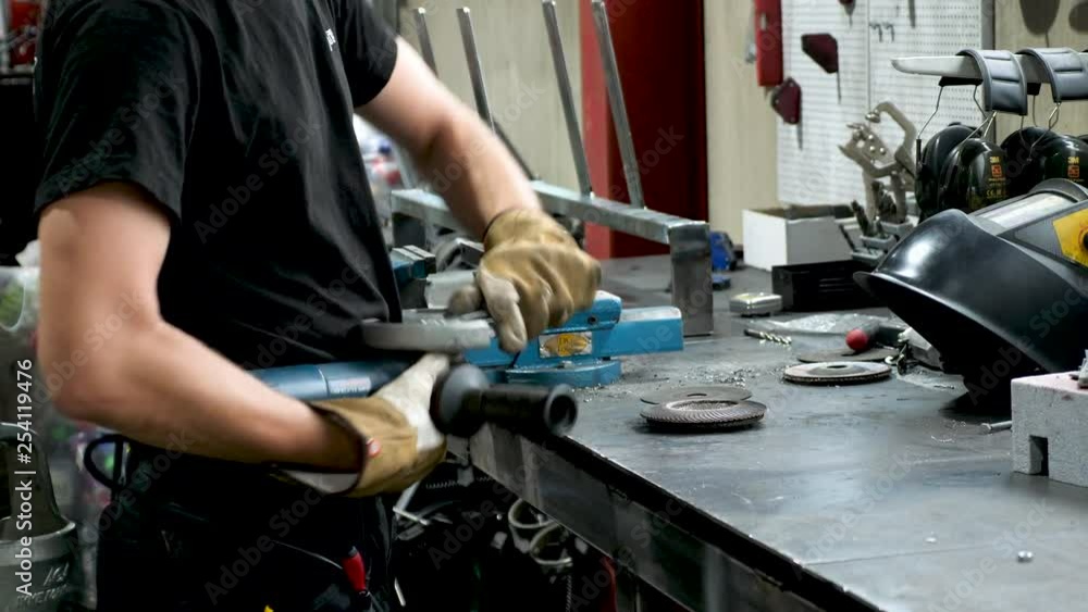 Static shot, of a welder, tightening a nut, fixing his gear, at his table, in south Norway Static shot, of a welder, tightening a nut, fixing his gear, at his table, in south Norway