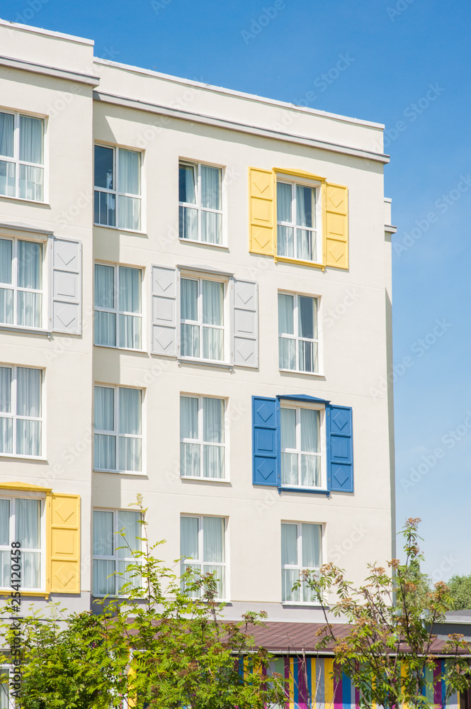 View to facade of building with windows with colored wooden shutters. View to facade of building with windows with colored wooden shutters.