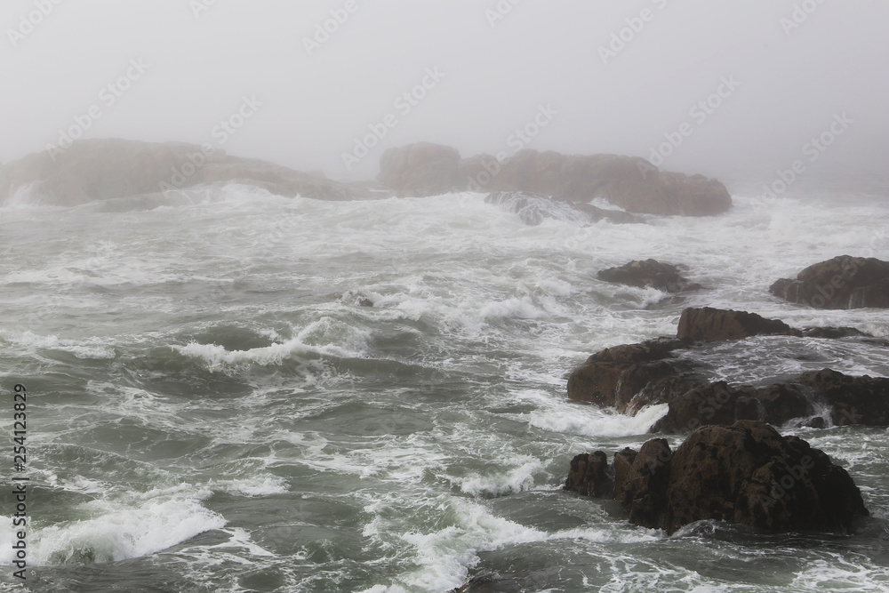 Stormy ocean with dark rock in the foreground
