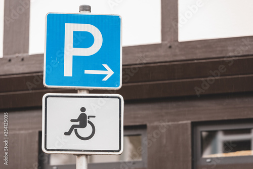 two signs with a P for parking and a symbol of a wheelchair for a disabled parking space