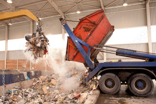 Truck dumps waste to the incinerator, hole where the big grab take the rubbish and put it into fire. All waste is being processed in the incinerator and burning without any air pollution. photo