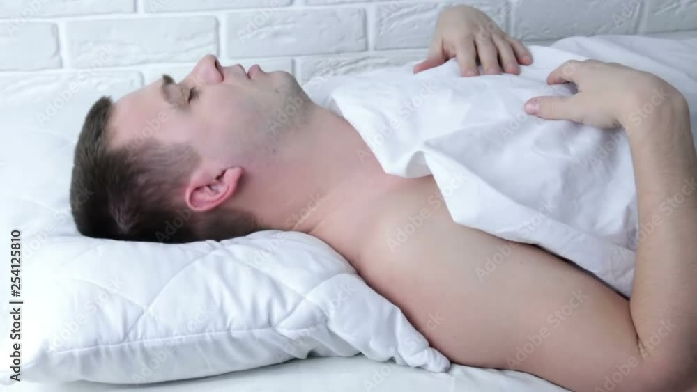 Young man scared in his bed having nightmares Young man scared in his bed having nightmares