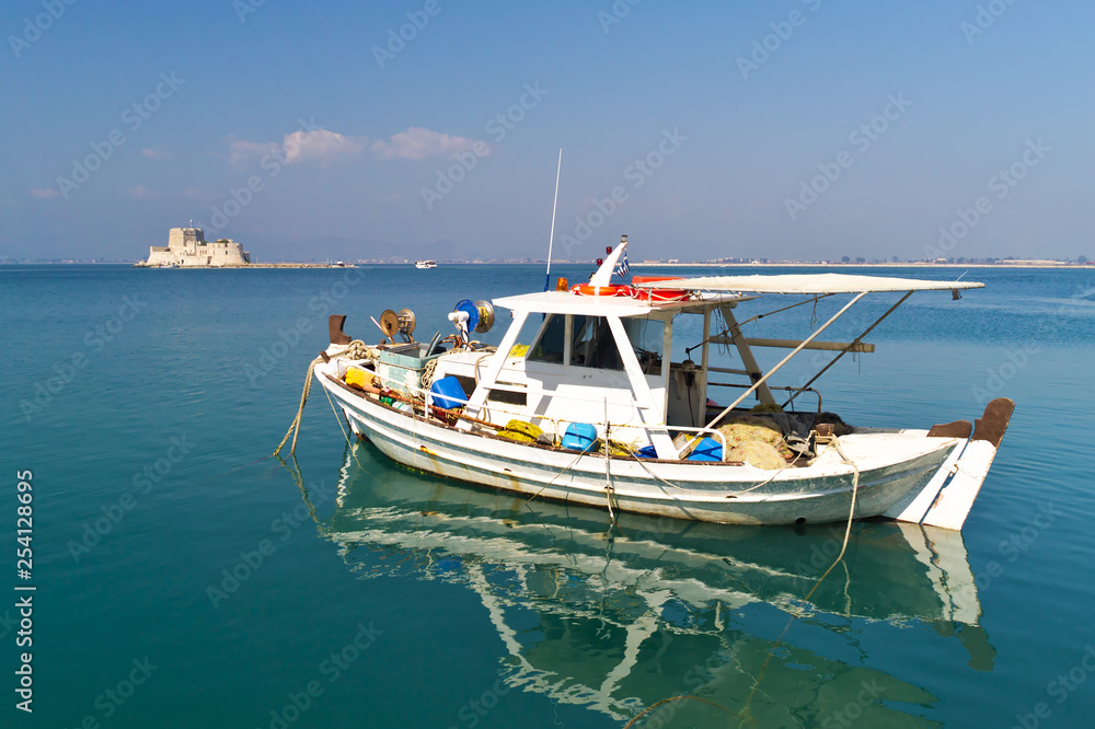 Boat in Nafplio Greece, with mpourtzi castle in background. A bright sunny day.