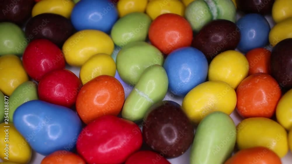 Colorful chocolate candy drops balls chocolates closeup texture video on rolling rotating looping plate Colorful chocolate candy drops balls chocolates closeup texture video on rolling rotating looping plate