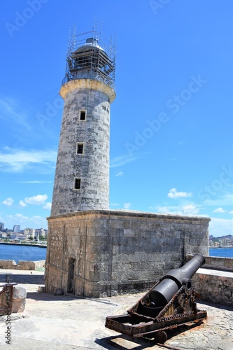 Faro del Morro de la Habana en reparación a abajo un cañón antiguo oxidado, al fondo vista de la bahía de la habana en La Habana, Cuba