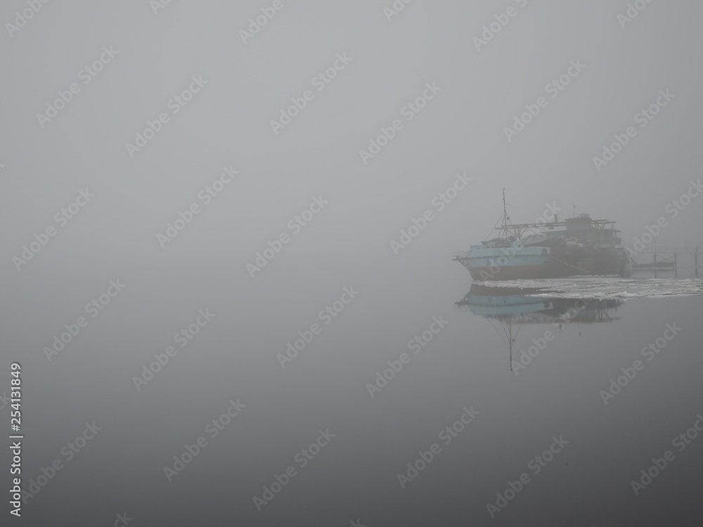 Old rusty ship in fog in spring