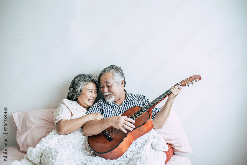 Senior couple  relax playing acoustic guitar in bed room