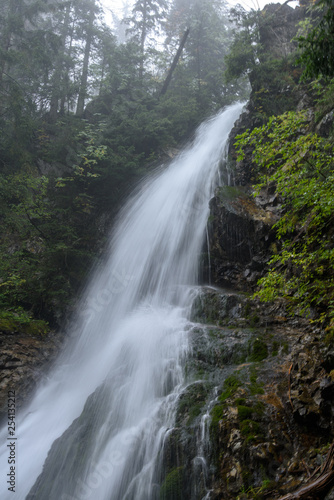 fast mountain rocky river in forest with waterfall