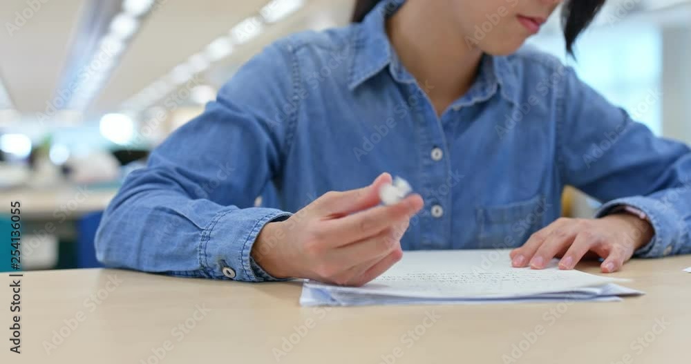 Woman write on paper in library Woman write on paper in library