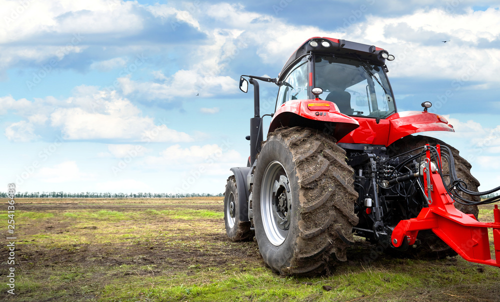 Tractor working in a field against a cloudy sky Tractor working in a field against a cloudy sky