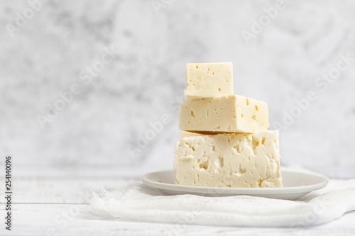 Sliced feta cheese on light background. High key. With copy space