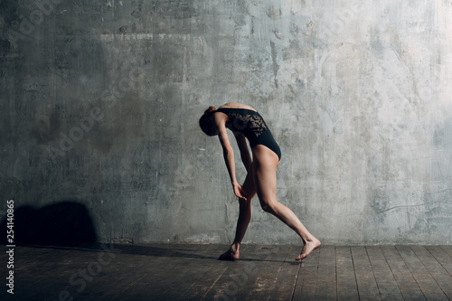 Ballerina female. Young beautiful woman ballet dancer, dressed in professional outfit, pointe shoes and black body.