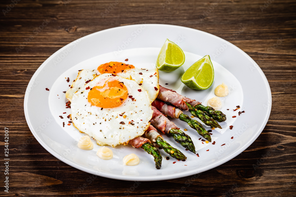 Fried egg with asparagus on white background Fried egg with asparagus on white background