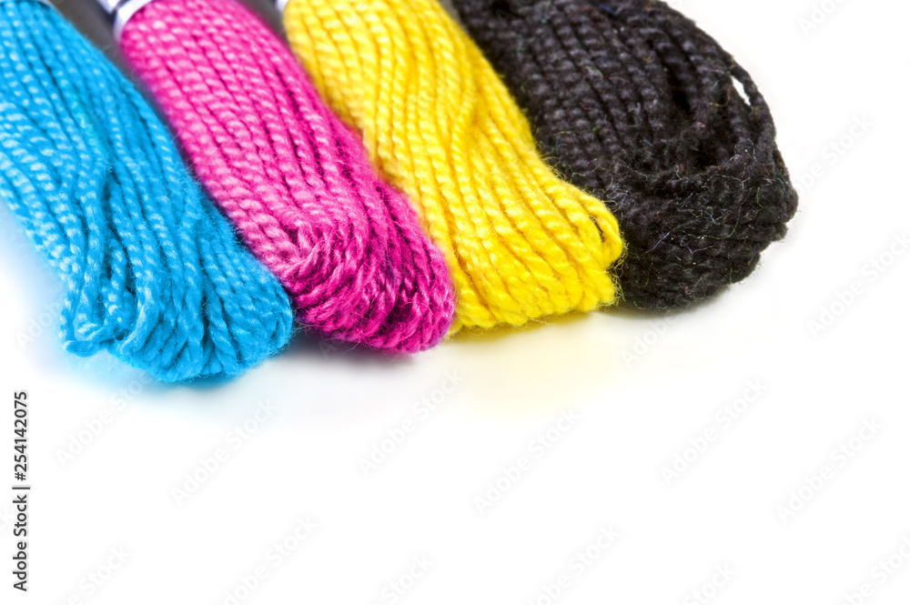 Four sawing silk threads in the prepress colors cmyk with white copy space for text. Four sawing silk threads in the prepress colors cmyk with white copy space for text.
