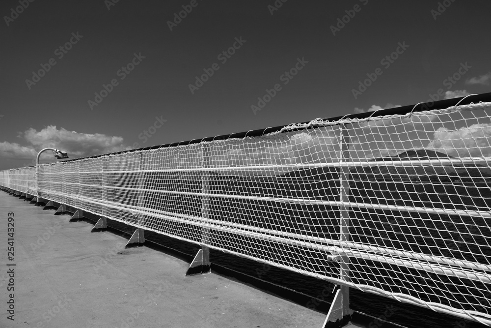 Black and white artistic and geometrical photo of a ship's railing, with the sea in the background. Black and white artistic and geometrical photo of a ship's railing, with the sea in the background.