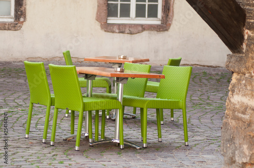 closeup of green chairs at the terrace of the restaurant in the street