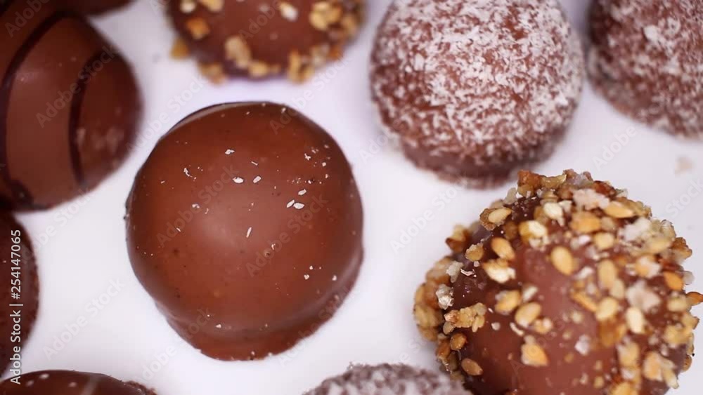 Bonbon chocolates closeup texture video on rolling rotating looping plate Bonbon chocolates closeup texture video on rolling rotating looping plate