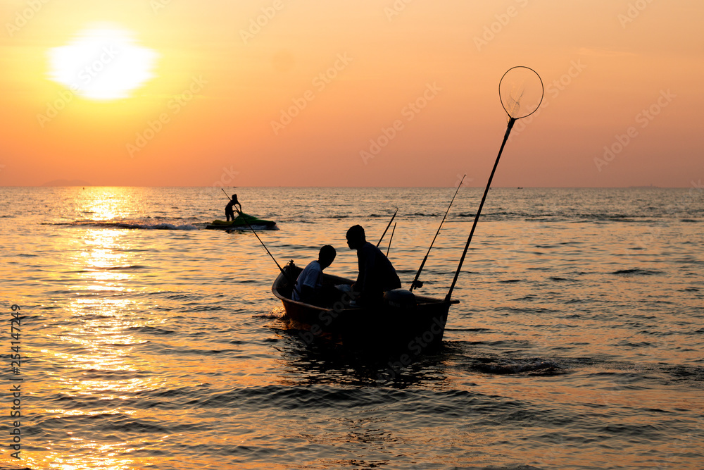 2 fisherman on the boat  in the sea is fishing when sunset in pattay
