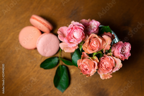 pink roses in a vase with macaroons © Magneya Photography
