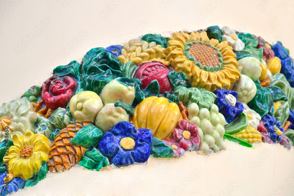 Multi-colored ceramic ornament of flowers, fruits, vegetables, cones, leaves