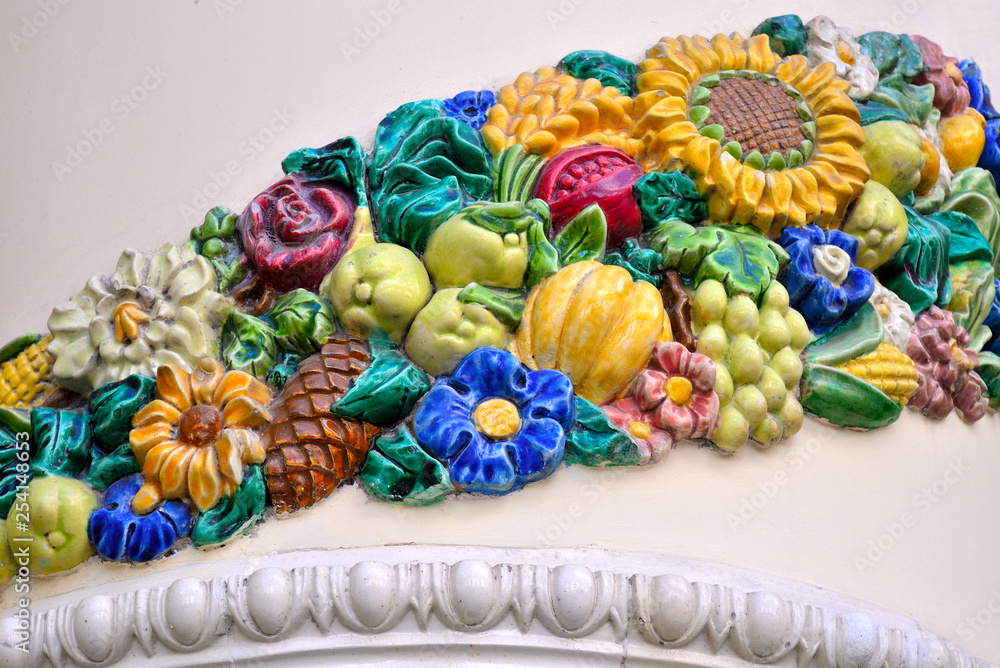 Multi-colored ceramic ornament of flowers, fruits, vegetables, cones, leaves