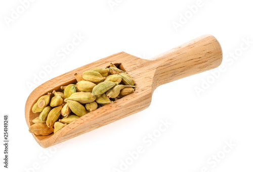 green cardamon isolated in wood scoop on white background
