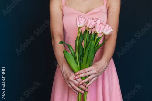 bouquet of pink tulips in the hands of a girl