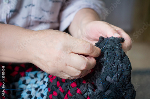 Elderly woman sewing with needle and thread doing hand work