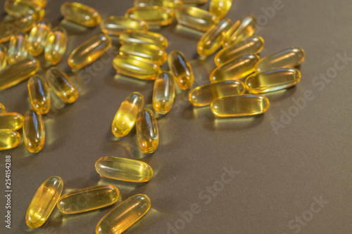 Gelatin capsules with the medicine are scattered across the table.