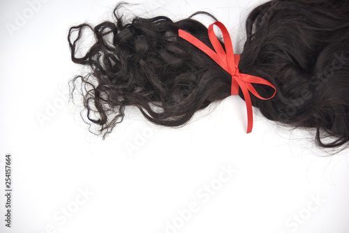 Dark curly hair with red lace on the white background