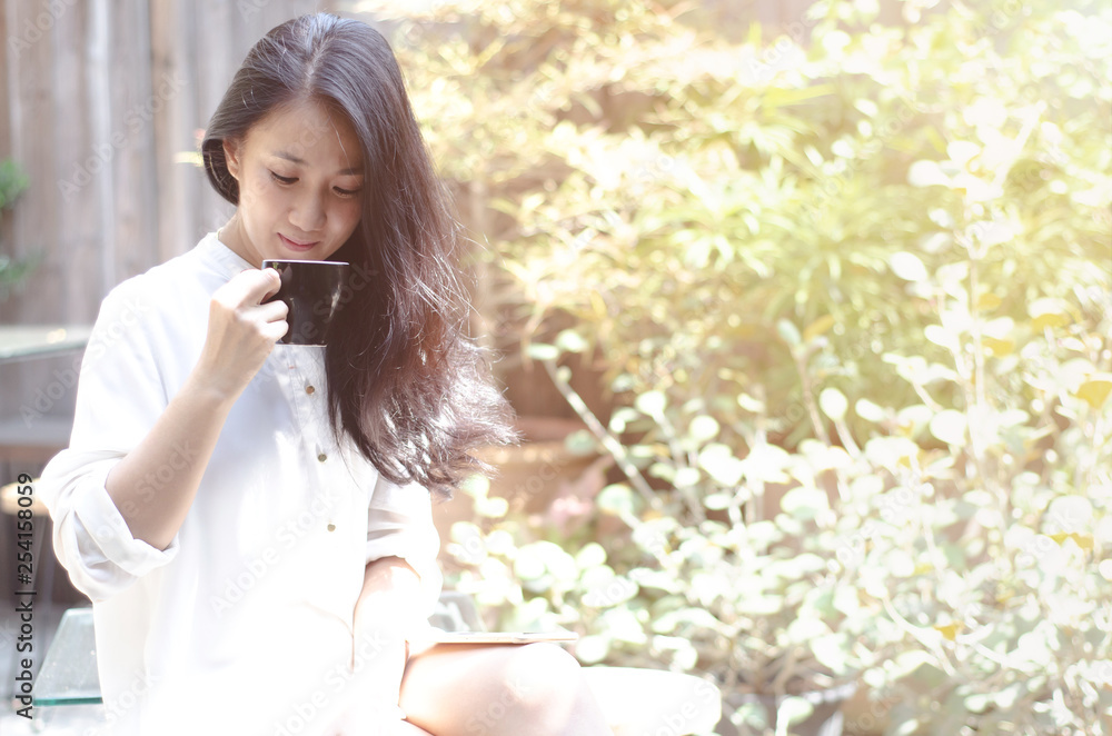 Beautiful woman holding a white cup of coffee in the morning bedroom.Gray bedroom, she is drinking coffee. Beautiful woman holding a white cup of coffee in the morning bedroom.Gray bedroom, she is drinking coffee.