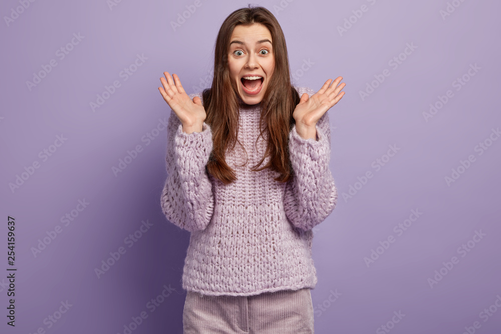 Delighted beautiful impressed woman holds clasped hands, being amused and surprised by good thrilling news, opens mouth, shakes raised palms, gazes amazed, tells something awesome to best friend Delighted beautiful impressed woman holds clasped hands, being amused and surprised by good thrilling news, opens mouth, shakes raised palms, gazes amazed, tells something awesome to best friend
